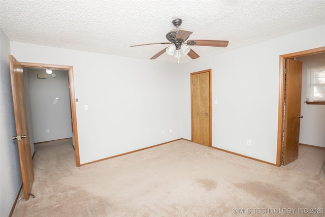 unfurnished bedroom featuring light carpet, a textured ceiling, and ceiling fan