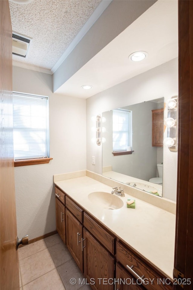 bathroom featuring toilet, crown molding, a textured ceiling, vanity, and tile patterned flooring