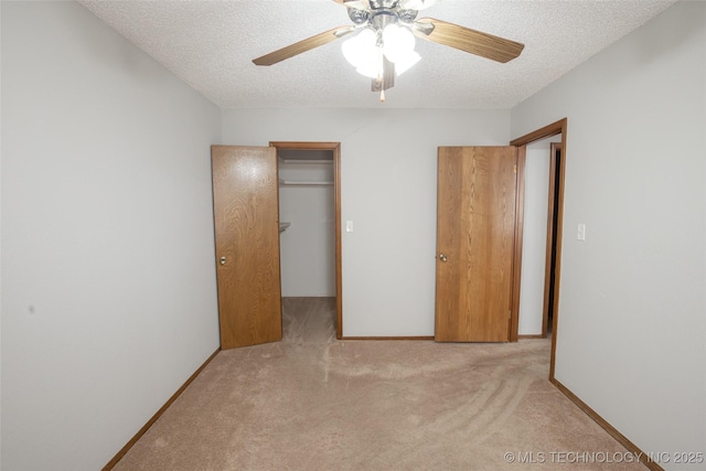 unfurnished bedroom featuring a textured ceiling, light colored carpet, a closet, and ceiling fan