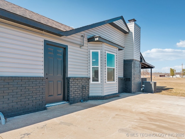 doorway to property featuring a patio and central AC unit