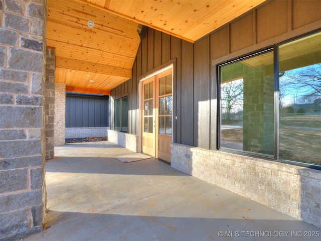 doorway to property featuring brick siding and board and batten siding