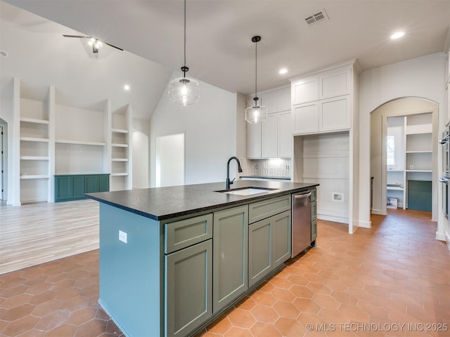 kitchen featuring visible vents, a sink, dark countertops, white cabinetry, and arched walkways