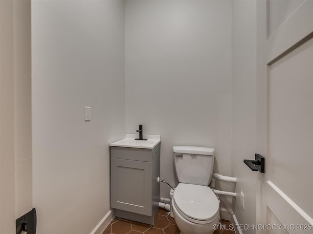 bathroom with tile patterned floors, toilet, vanity, and baseboards