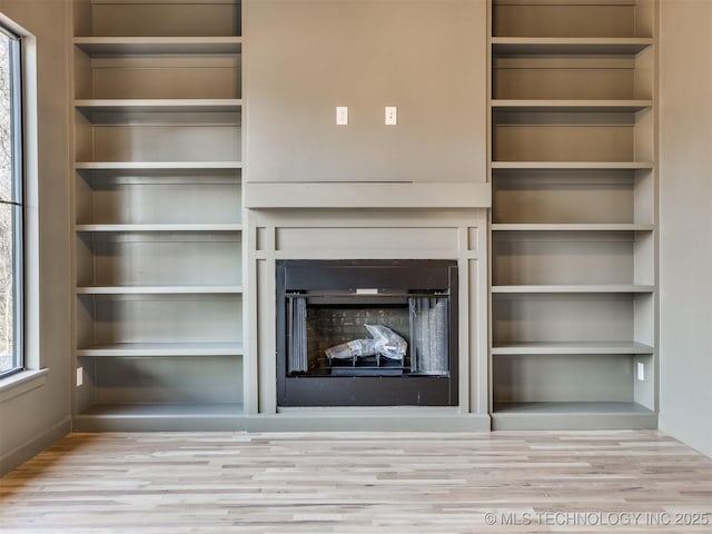 unfurnished living room with a fireplace and wood finished floors