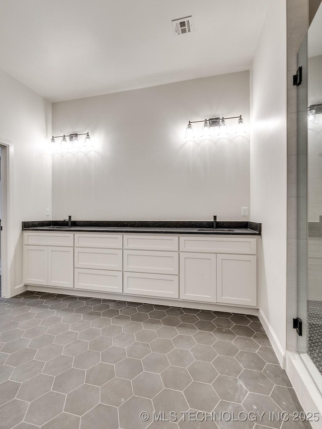 full bathroom featuring a sink, visible vents, a stall shower, and double vanity