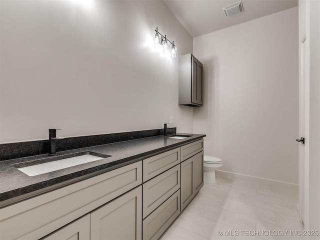 full bathroom featuring a sink, visible vents, toilet, and double vanity