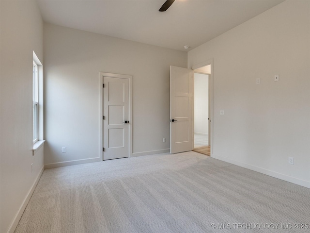 unfurnished bedroom with baseboards, light carpet, and ceiling fan