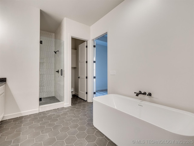 full bath with a shower stall, a freestanding tub, toilet, and tile patterned floors