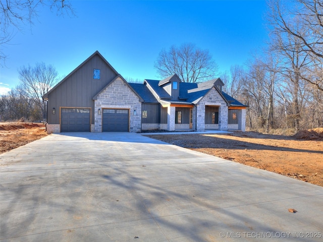 view of front facade with board and batten siding, concrete driveway, an attached garage, and stone siding