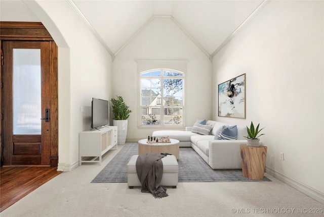 carpeted living room featuring ornamental molding and vaulted ceiling