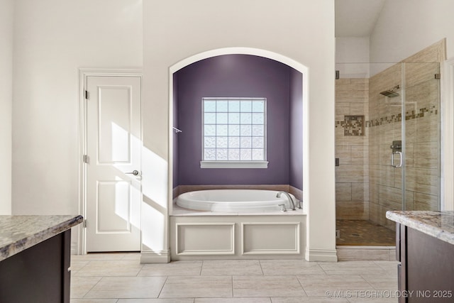 bathroom featuring a stall shower, a bath, and vanity