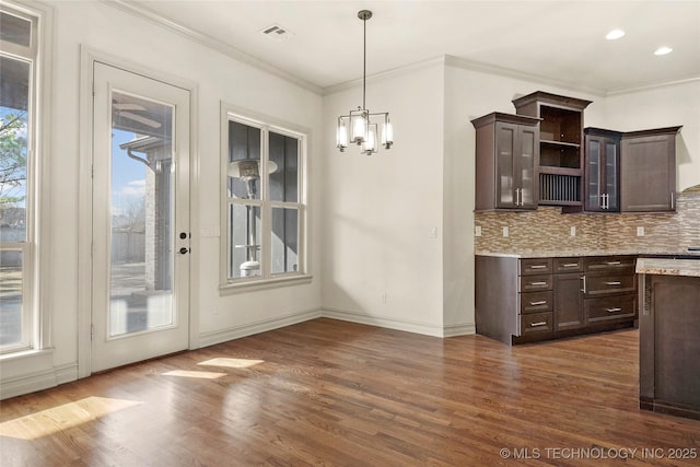 kitchen with decorative light fixtures, dark hardwood / wood-style floors, a wealth of natural light, and dark brown cabinetry