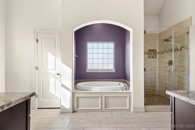 full bath with a bath, vanity, and a stall shower