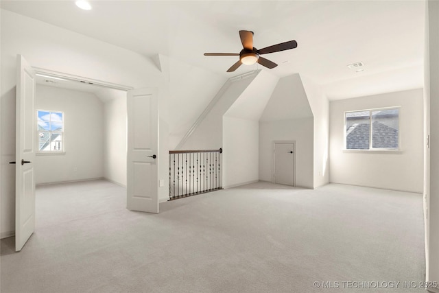 additional living space featuring ceiling fan, light colored carpet, and lofted ceiling