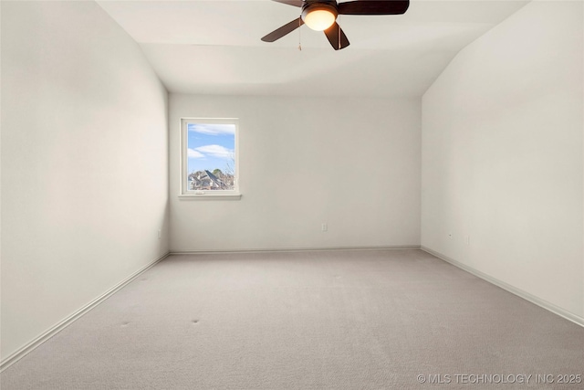 spare room featuring vaulted ceiling, ceiling fan, and light colored carpet