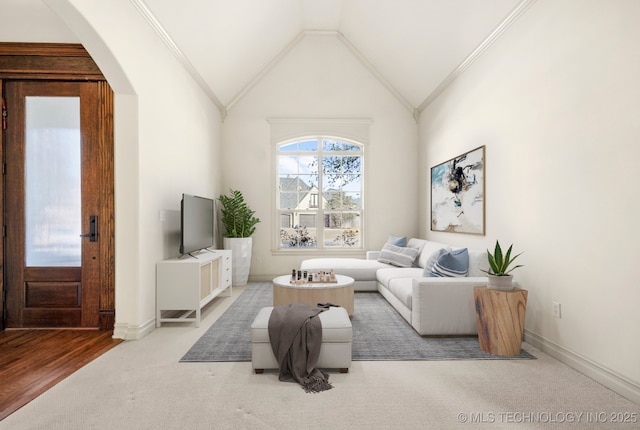 living area with baseboards, arched walkways, lofted ceiling, and carpet