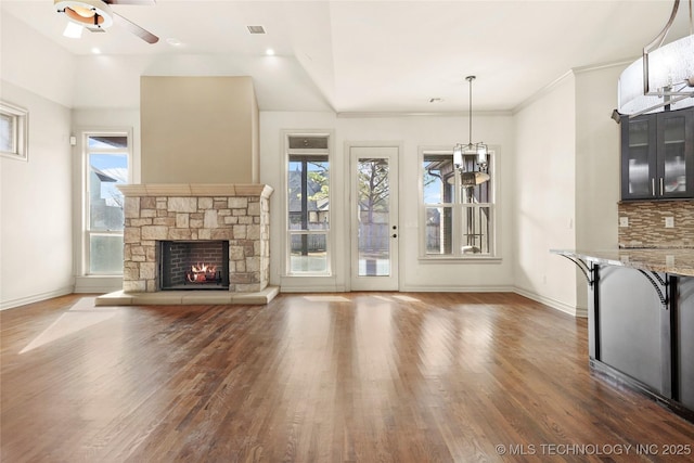 unfurnished living room featuring ceiling fan, dark hardwood / wood-style floors, and a fireplace