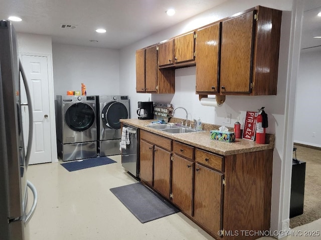 kitchen with sink, independent washer and dryer, and appliances with stainless steel finishes