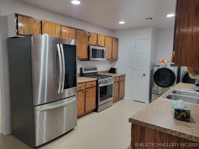 kitchen featuring sink, washer and dryer, and stainless steel appliances