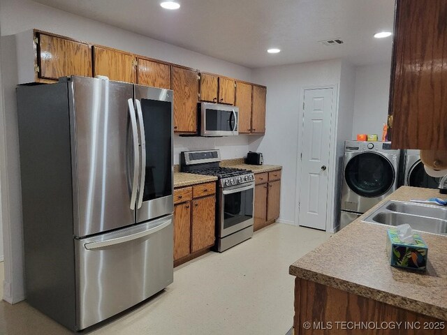 109 S E St, Eufaula, OK 74432 - kitchen featuring sink, washer and dryer, and stainless steel appliances