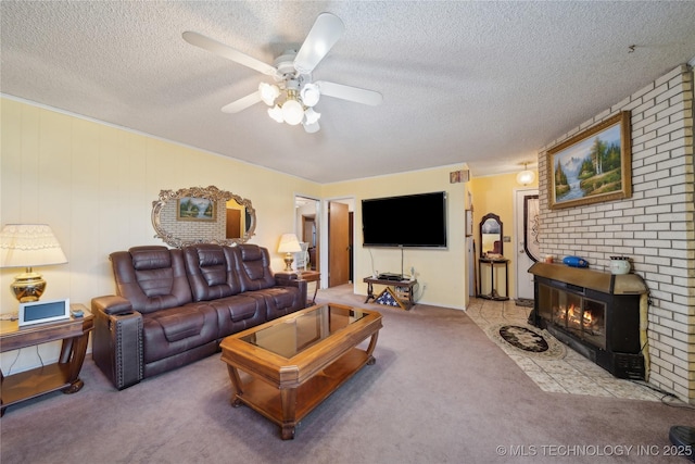 living room with ceiling fan, a textured ceiling, light carpet, and a large fireplace