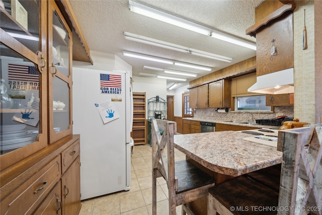 kitchen featuring kitchen peninsula, a kitchen breakfast bar, dishwasher, white refrigerator, and a textured ceiling