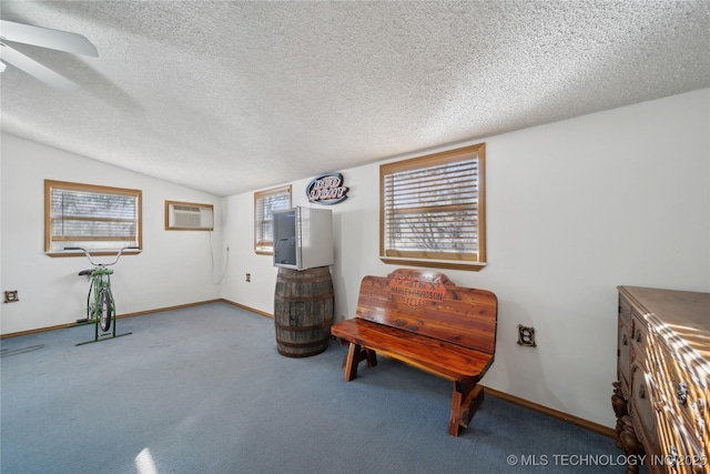 sitting room featuring a textured ceiling, lofted ceiling, carpet, and a wall mounted AC