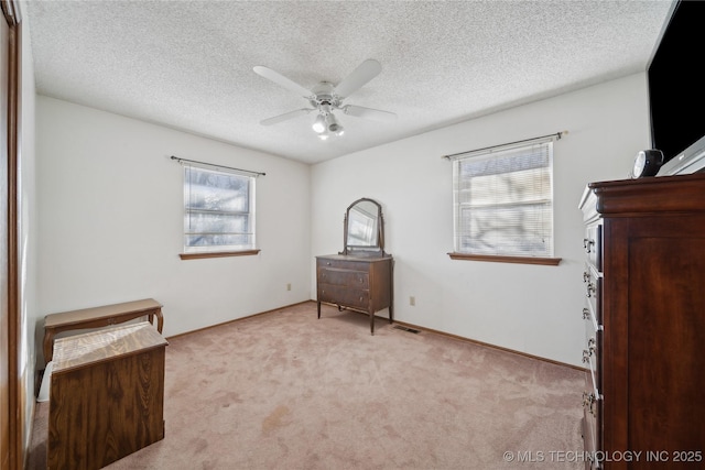 unfurnished bedroom featuring a textured ceiling, light colored carpet, and ceiling fan