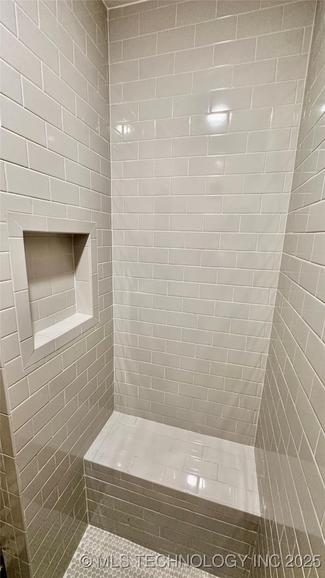 bathroom featuring tile patterned flooring and tiled shower