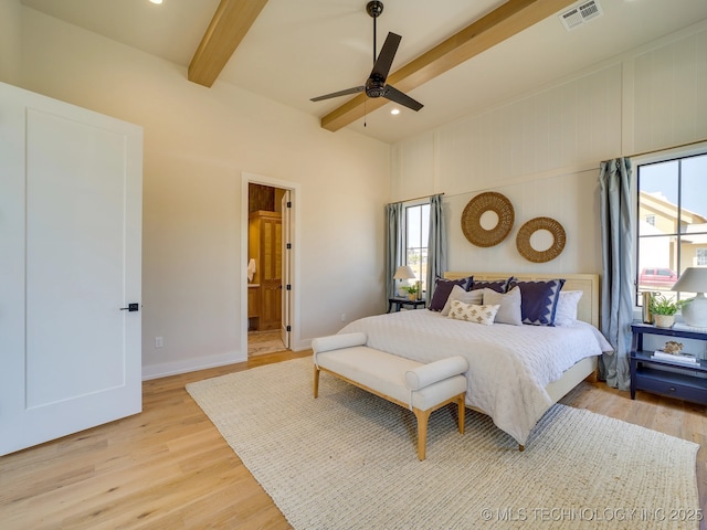 bedroom featuring beamed ceiling, ceiling fan, ensuite bathroom, and light hardwood / wood-style flooring