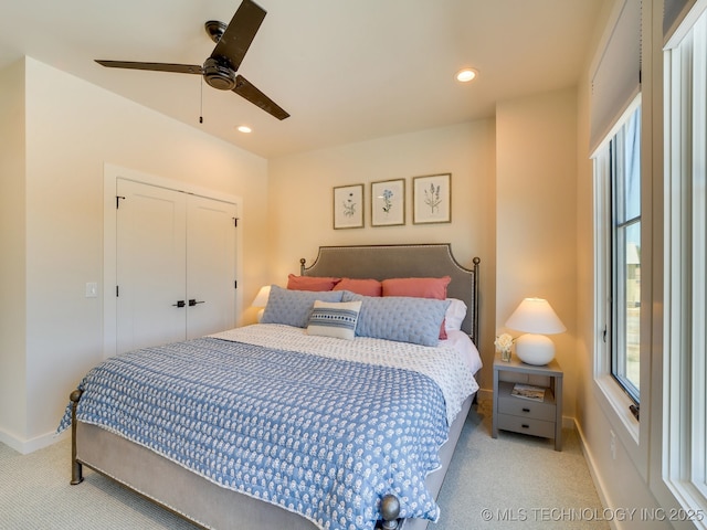 carpeted bedroom featuring ceiling fan and a closet