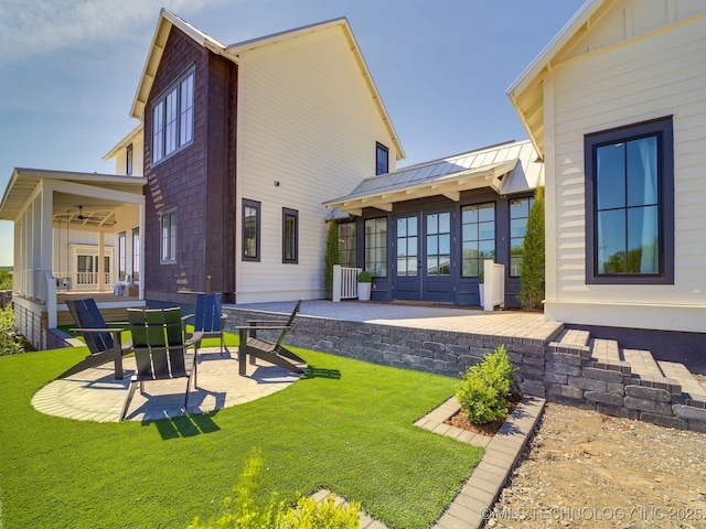 rear view of house with french doors, ceiling fan, a patio area, and a lawn