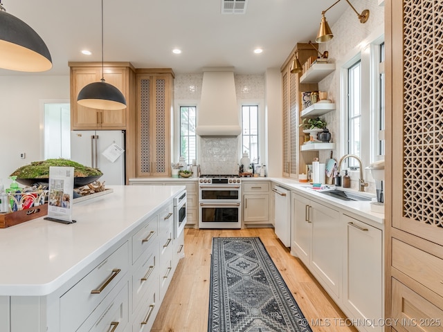 56 Center Ln N, Carlton Landing, OK 74432 - kitchen featuring premium appliances, premium range hood, open shelves, light countertops, and light wood finished floors