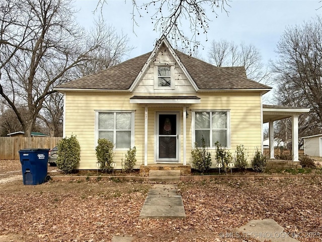 view of front of house featuring fence and a shingled roof