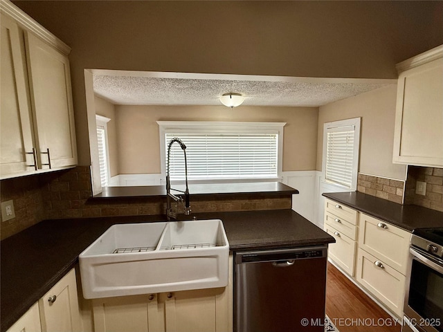 507 W Pawnee St, Cleveland, OK 74020 - kitchen with appliances with stainless steel finishes, dark countertops, a textured ceiling, backsplash, and dark wood-style flooring