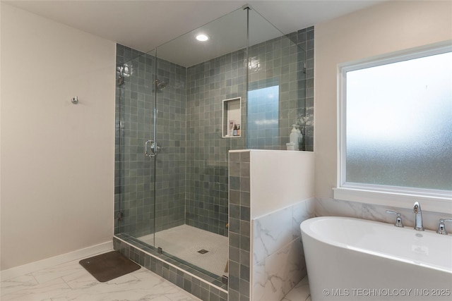 bathroom featuring a wealth of natural light and shower with separate bathtub