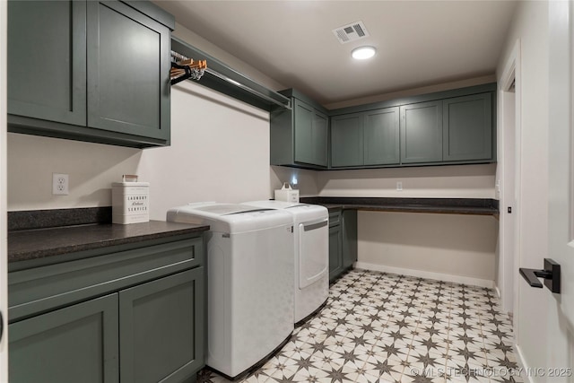 clothes washing area featuring cabinets and washing machine and clothes dryer