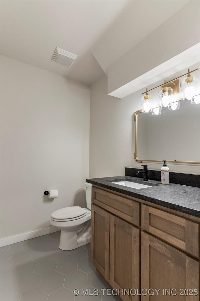 bathroom featuring tile patterned flooring, vanity, and toilet