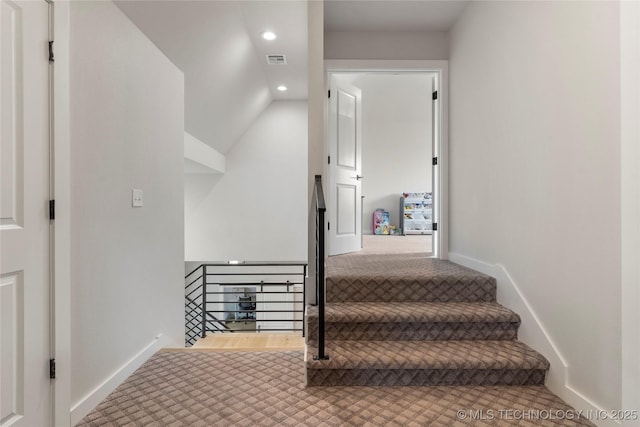 stairway with vaulted ceiling and carpet