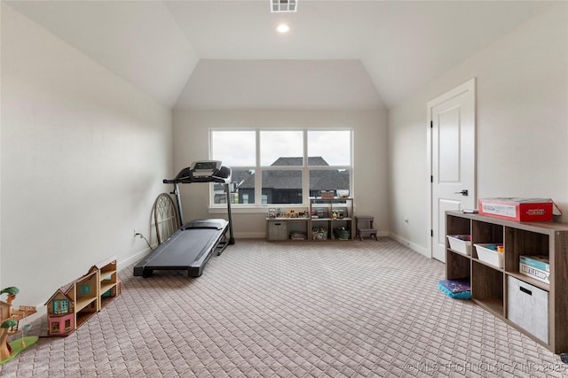 workout room featuring vaulted ceiling and light colored carpet