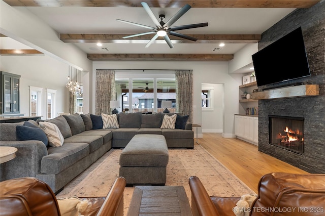 living room featuring a fireplace, ceiling fan, light hardwood / wood-style floors, and beamed ceiling