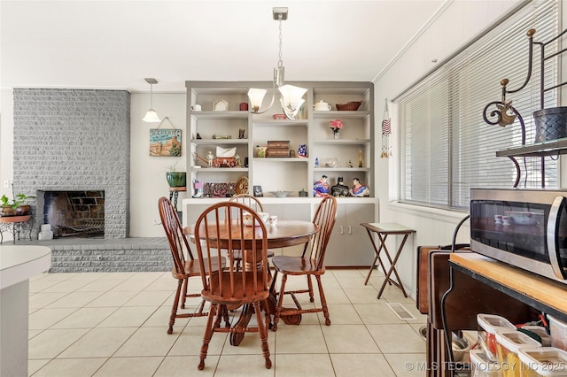 dining area with a fireplace and light tile patterned floors