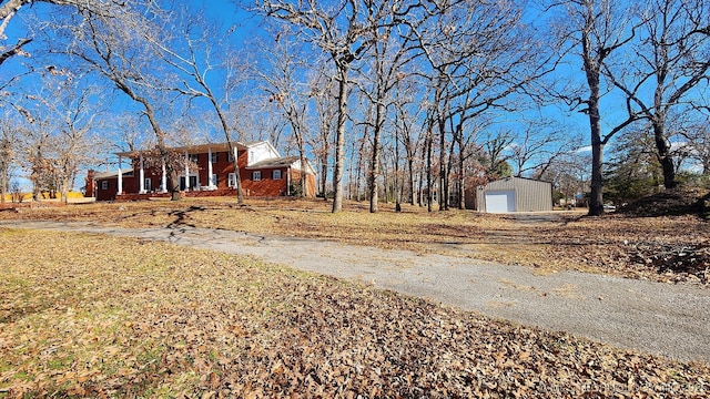 exterior space with a garage, covered porch, and an outbuilding