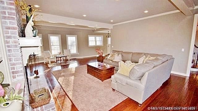 living room with dark hardwood / wood-style flooring, crown molding, and a fireplace