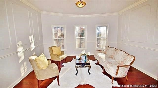 sitting room with dark hardwood / wood-style flooring and ornamental molding