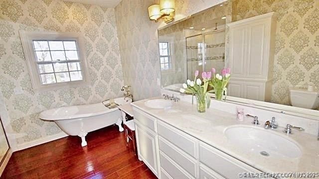 bathroom featuring hardwood / wood-style floors, independent shower and bath, and vanity