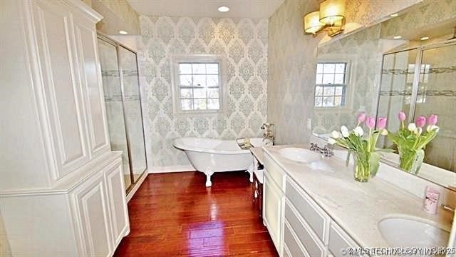 bathroom featuring wood-type flooring, vanity, and shower with separate bathtub