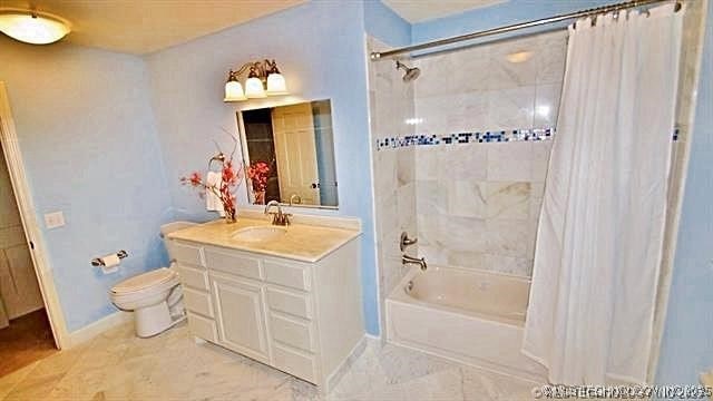 full bathroom featuring toilet, shower / tub combo, tile patterned floors, and vanity