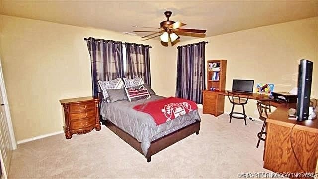 bedroom featuring ceiling fan and carpet