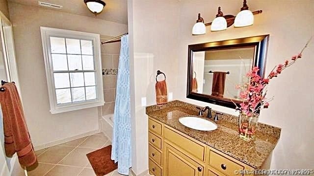 bathroom with vanity, shower / bath combo, and tile patterned flooring